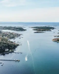 Flygbild över skärgården med öar, bryggor och villor vid vattnet