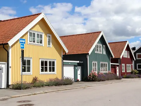 Rad av färgglada trähus med tegeltak längs en gata